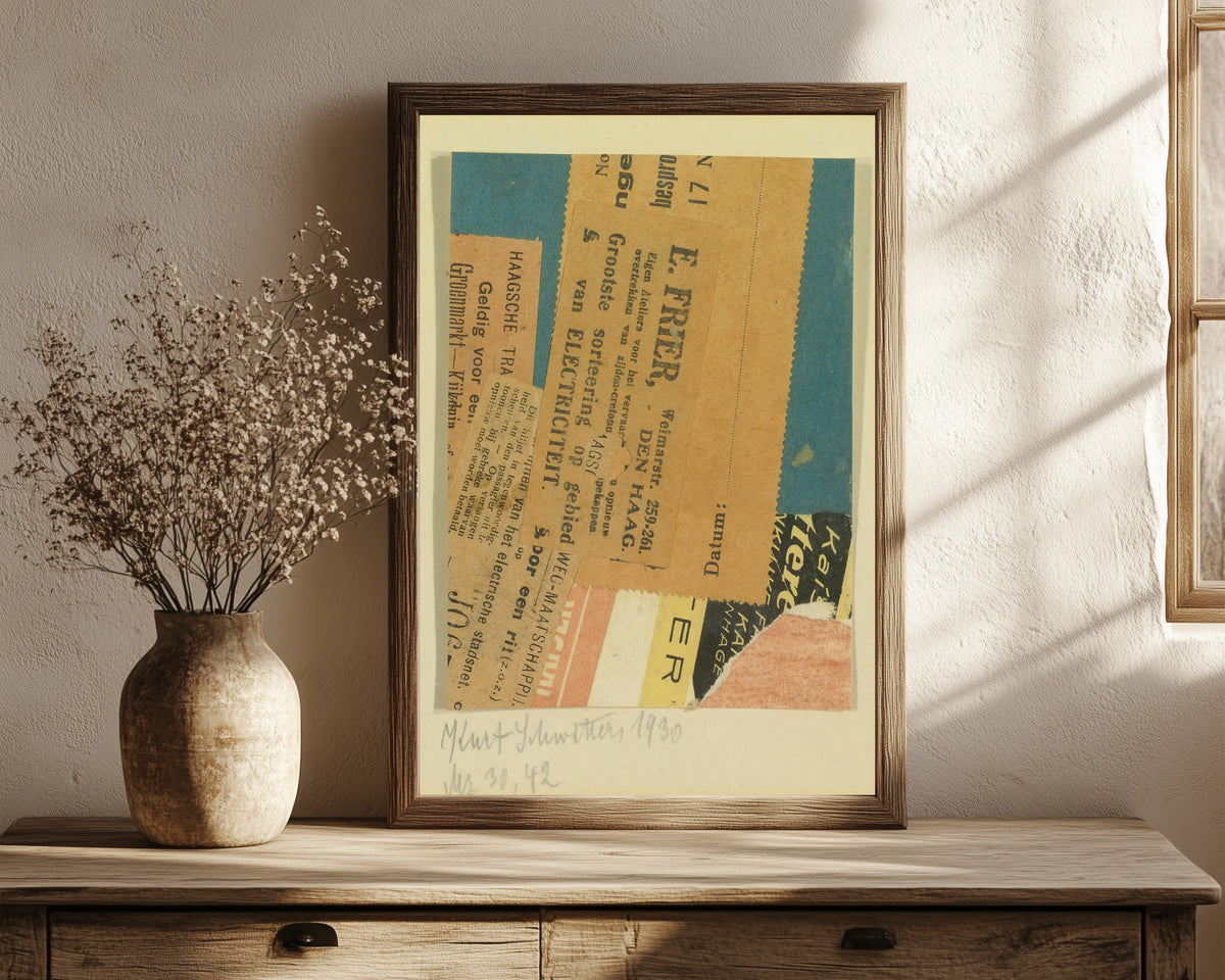 Framed art print of Merz 30, 42 by Kurt Schwitters, in a dark wood frame leaning on a rustic console beside dried flowers
