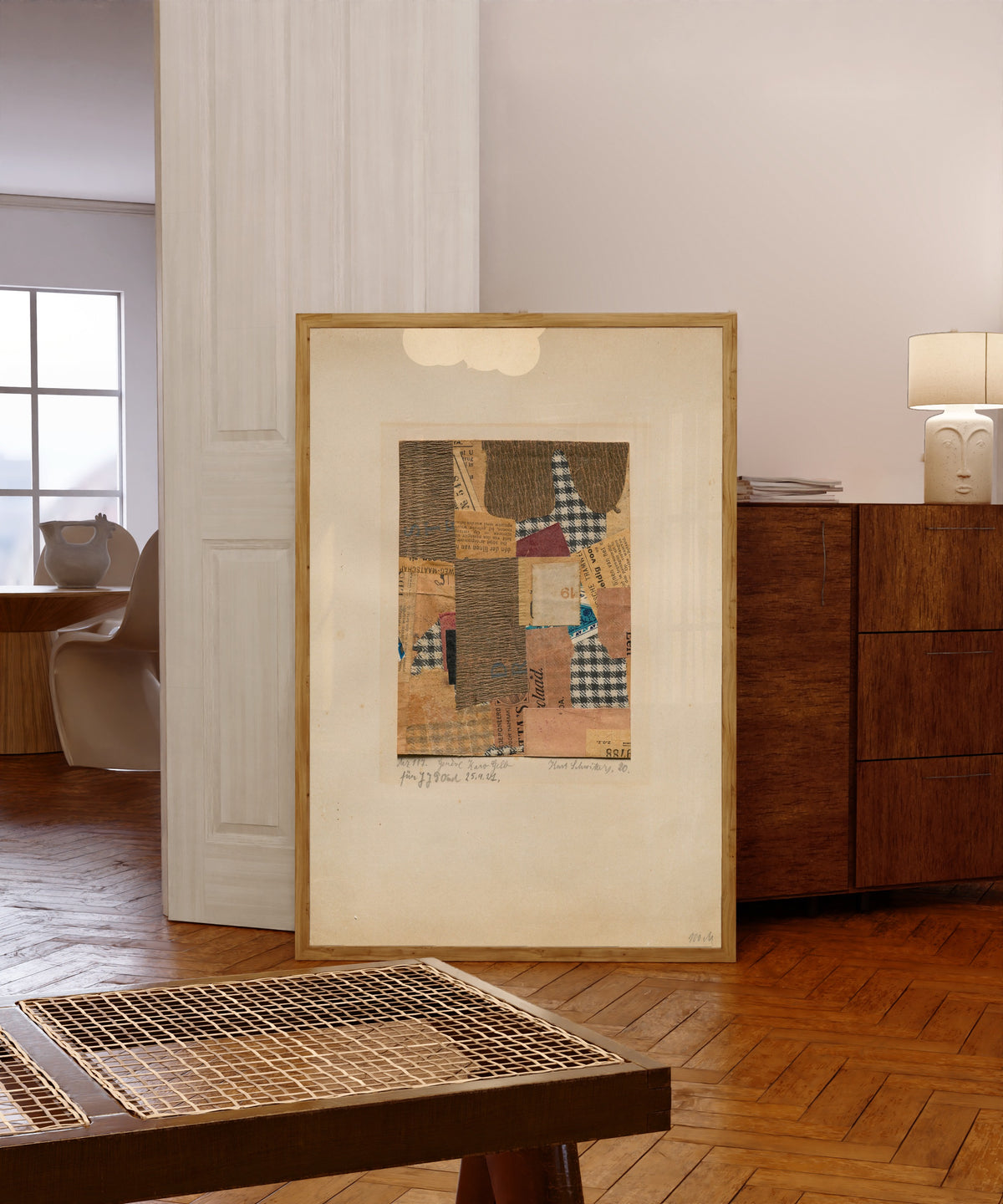 Framed art print of Mz 117. Genève Karo Gelb by Kurt Schwitters, in a light wood frame leaning in a warm room with a parquet floor