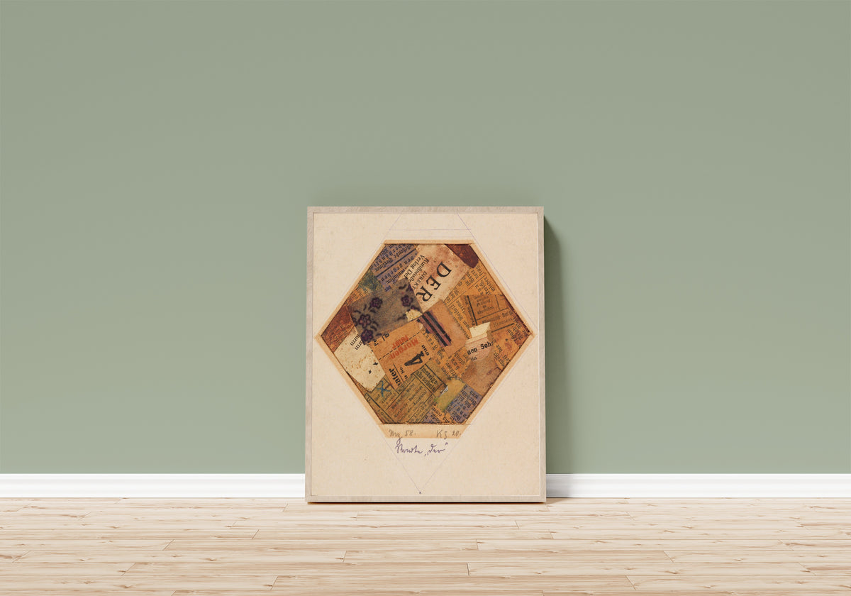 Framed art print of Mz 58, Worte 'der' by Kurt Schwitters, in a light wood frame leaning on a sage green wall above a wooden floor