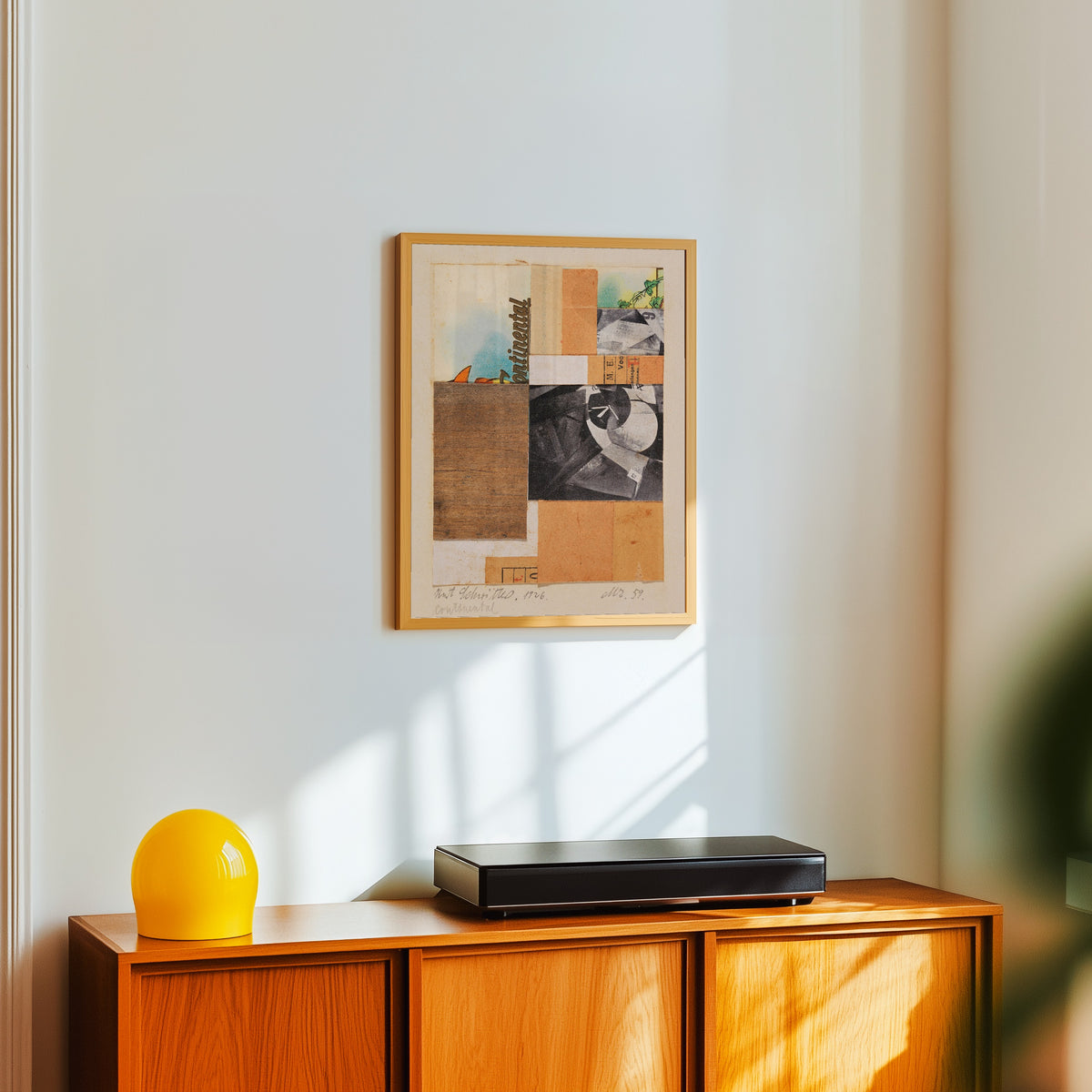 Framed art print of Mz. 59. Continental by Kurt Schwitters, in a light wood frame on a white wall above an orange sideboard