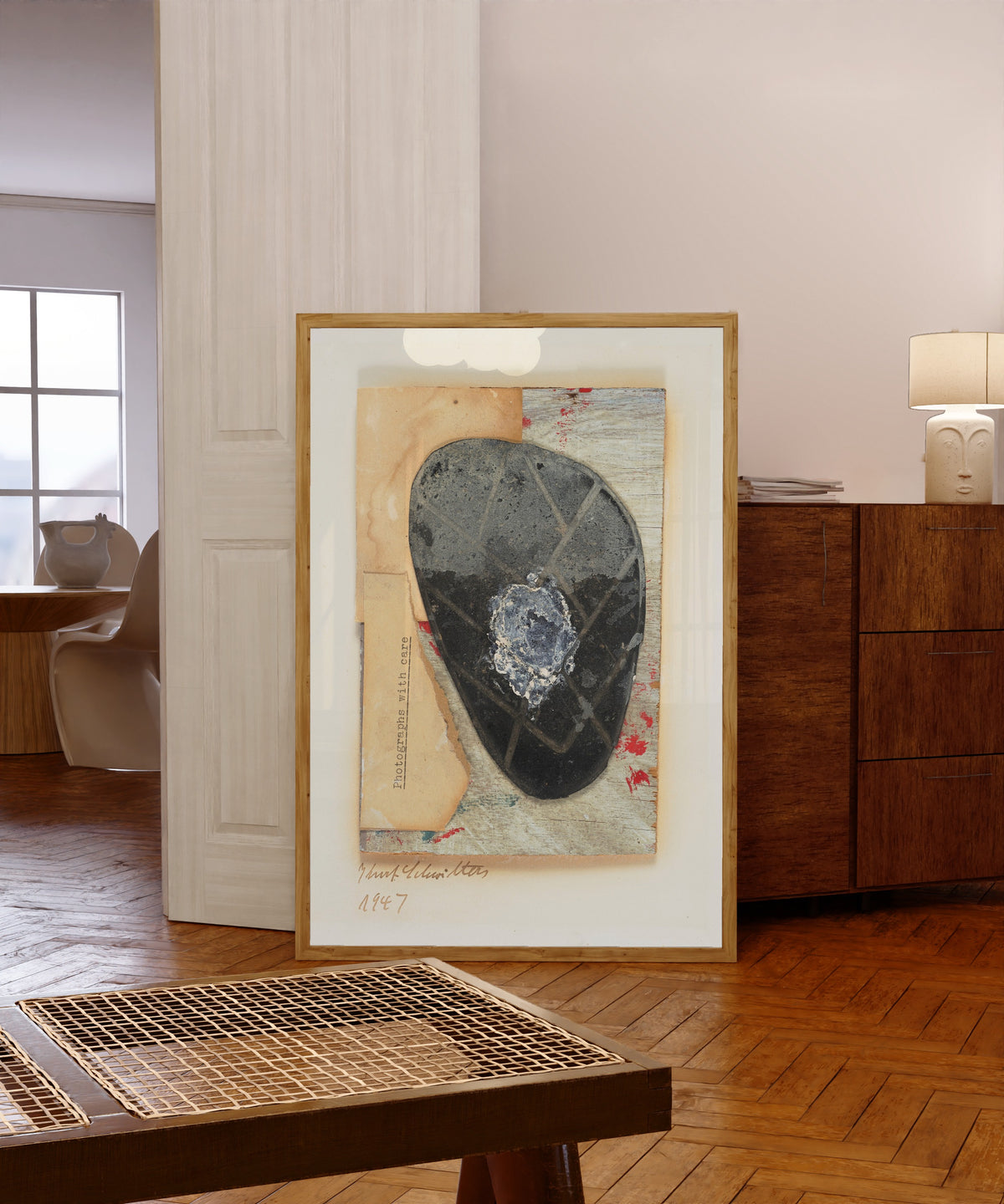 Framed art print of Ohne Titel (Fotografien mit Sorgfalt) by Kurt Schwitters, in a light wood frame leaning in a warm room with a parquet floor