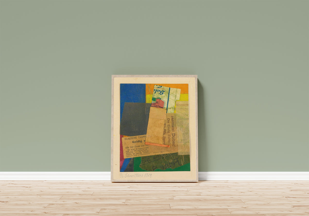 Framed art print of Ohne Titel (Geldig) by Kurt Schwitters, in a light wood frame leaning on a sage green wall above a wooden floor