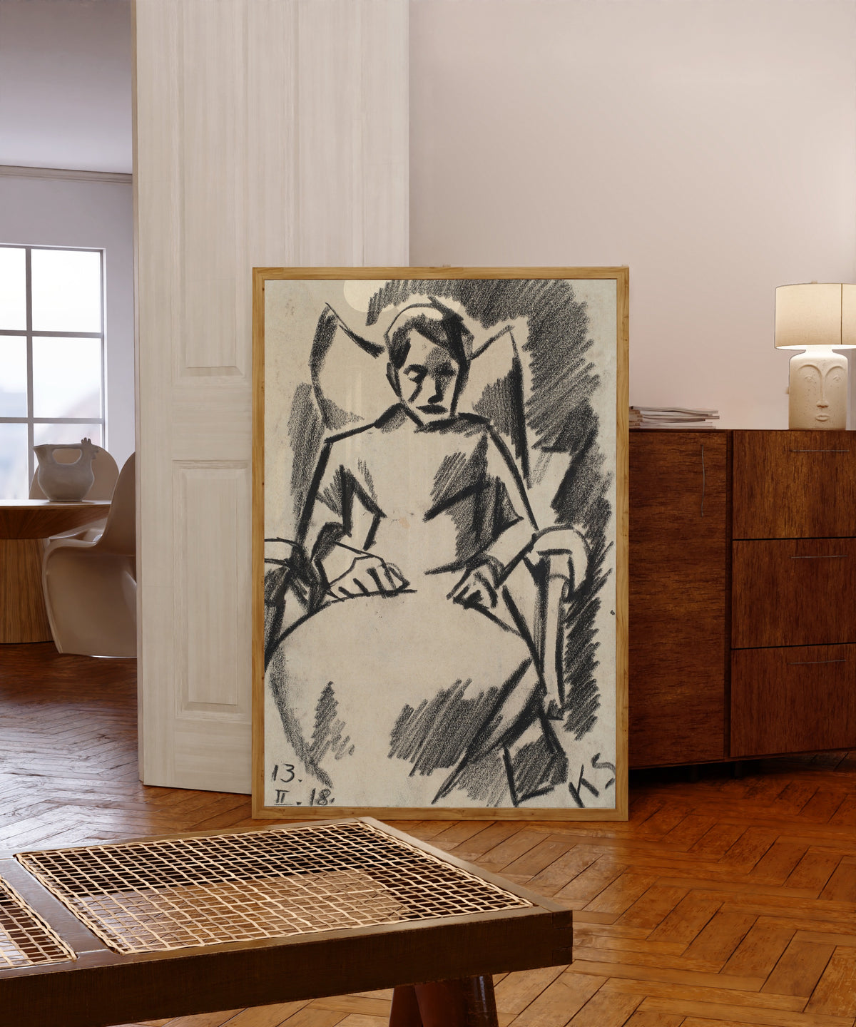 Framed art print of Z 112 Die Kranke by Kurt Schwitters, in a light wood frame leaning in a warm room with a parquet floor