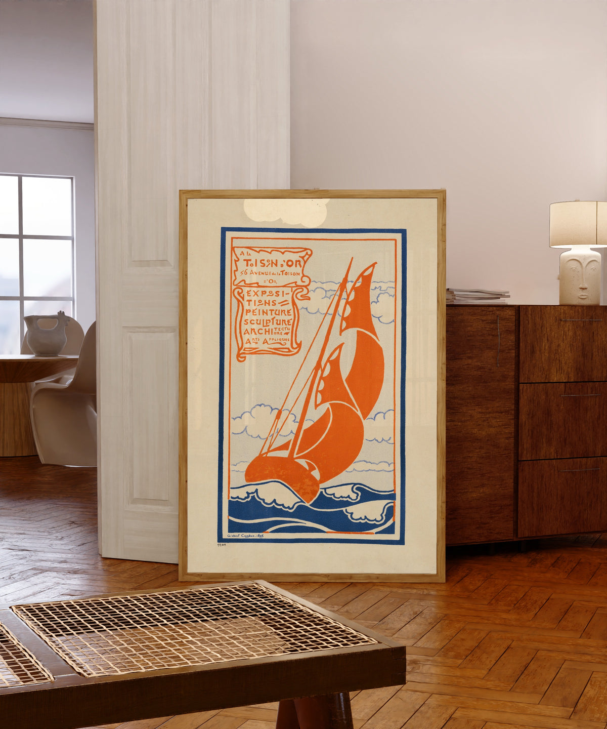 Framed art print of À la Toison d'Or: Expositions de Peinture, Sculpture… by Gisbert Combaz, in a light wood frame leaning in a warm room with a parquet floor