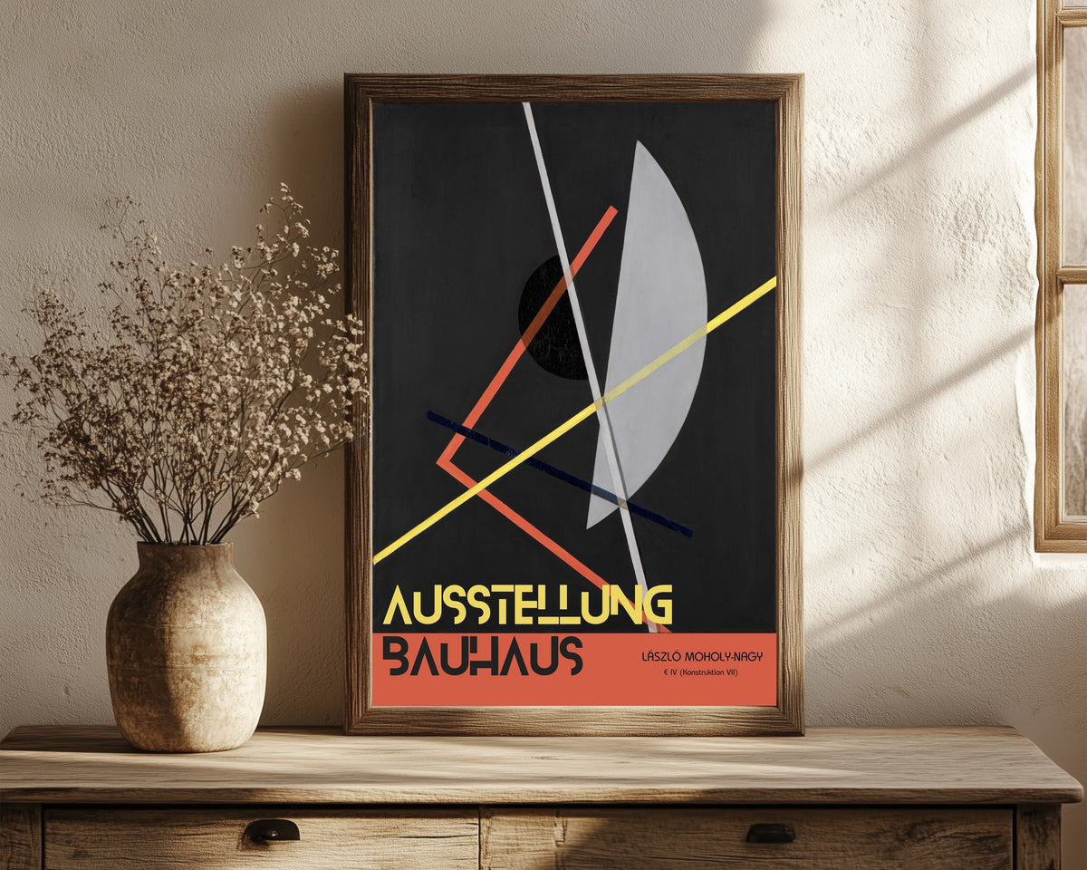 Framed art print of E IV (Konstruktion 8) by László Moholy-Nagy, in a dark wood frame leaning on a rustic console beside dried flowers