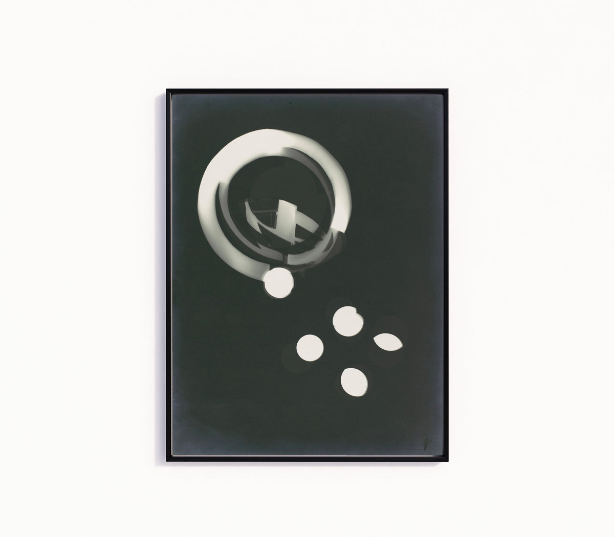 Framed art print of Fotogramm (1925) by László Moholy-Nagy, in a slim black frame on a plain white wall