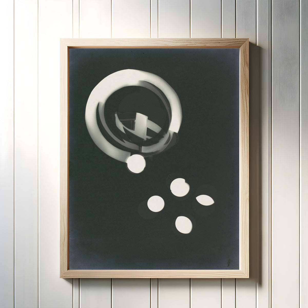 Framed art print of Fotogramm (1925) by László Moholy-Nagy, in a light wood frame on a white panelled wall