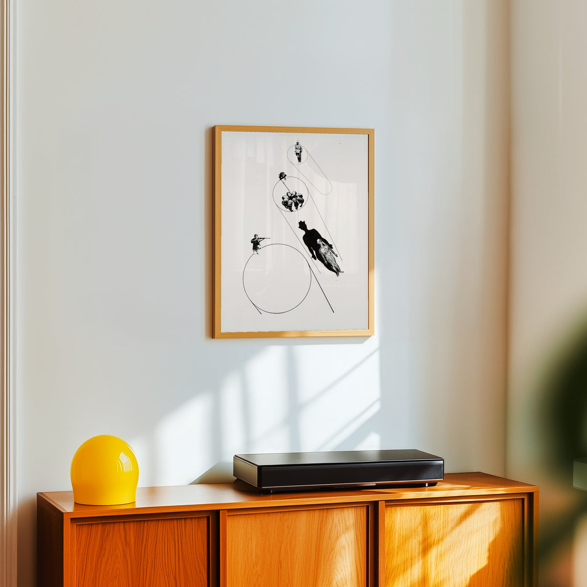 Framed art print of Target Practice (In the Name of the Law) by László Moholy-Nagy, in a light wood frame on a white wall above an orange sideboard
