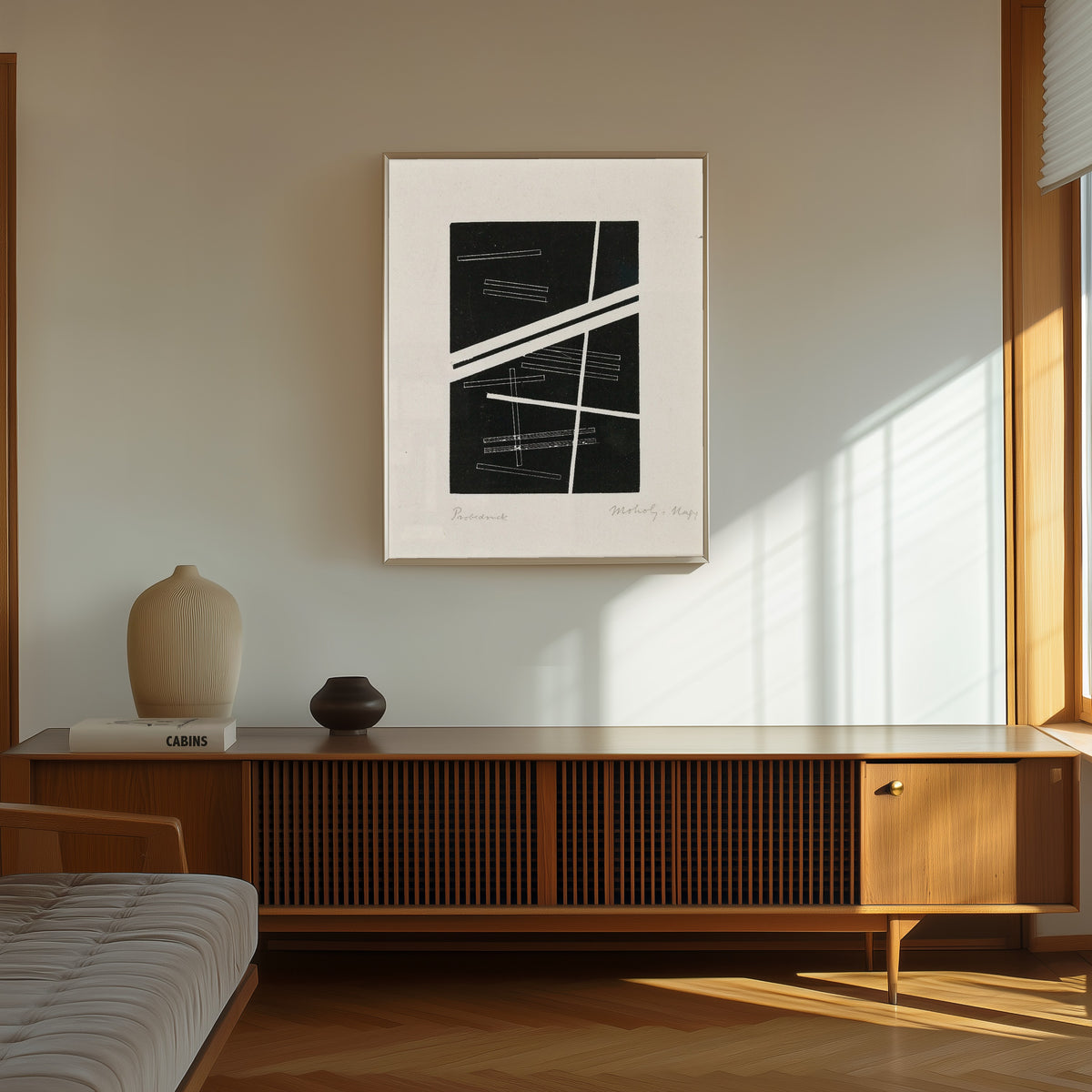 Framed art print of Untitled composition by László Moholy-Nagy, in a thin light frame on a sunlit wall above a wooden sideboard