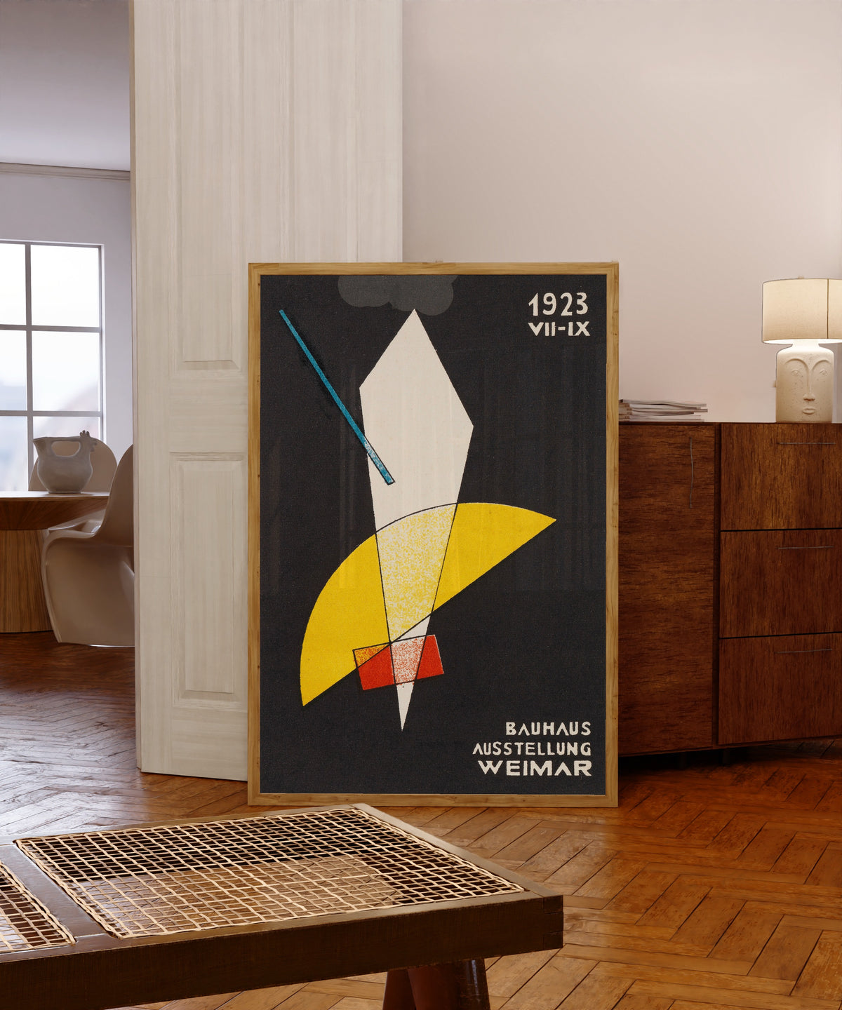 Framed art print of Weimar Bauhaus Postkarte Nr 7 by László Moholy-Nagy, in a light wood frame leaning in a warm room with a parquet floor