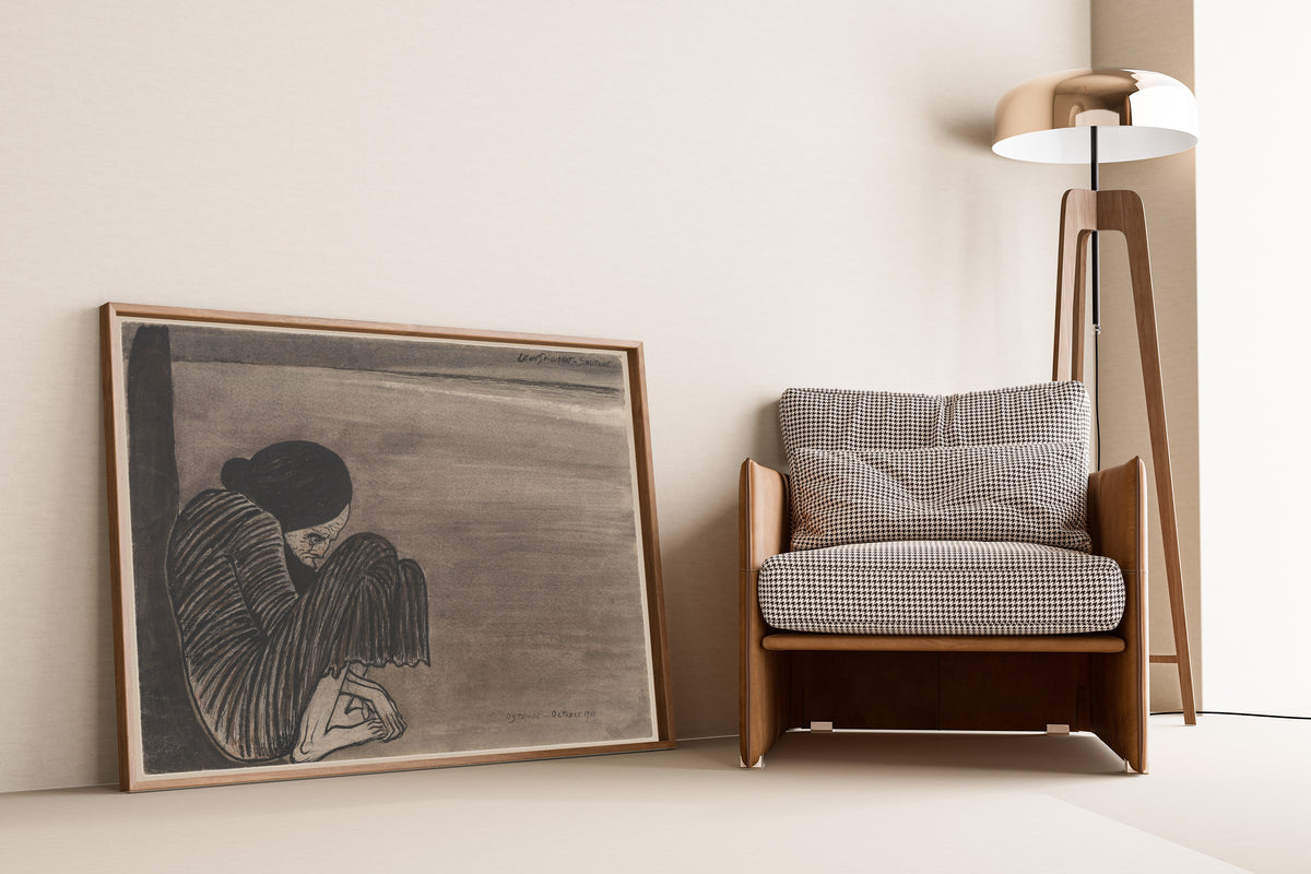 Framed art print of Solitude by Léon Spilliaert, leaning against a wall beside an armchair and a floor lamp
