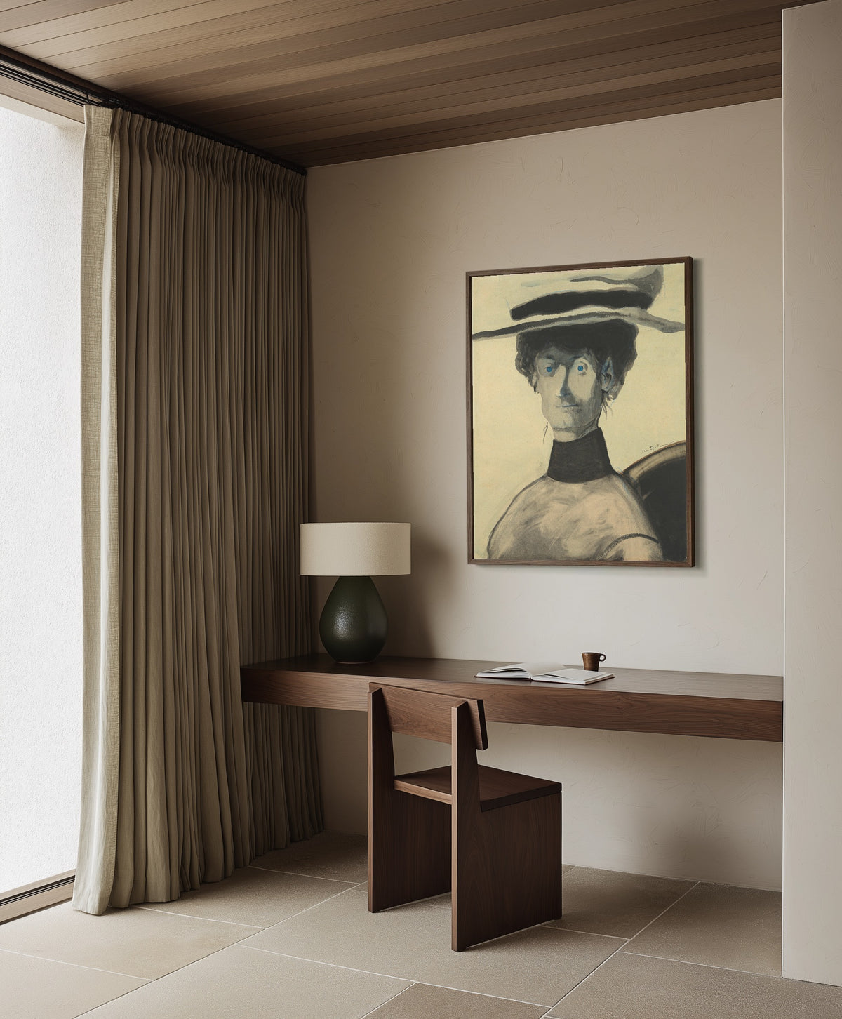 Framed art print of Vrouw met roze hoed by Léon Spilliaert, in a dark wood frame on a plaster wall above a walnut desk