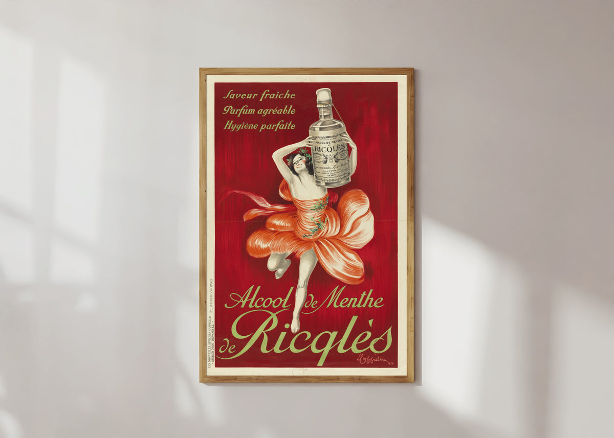 Framed art print of Alcool de menthe de Ricqlès by Leonetto Cappiello, in a light wood frame on a sunlit white wall