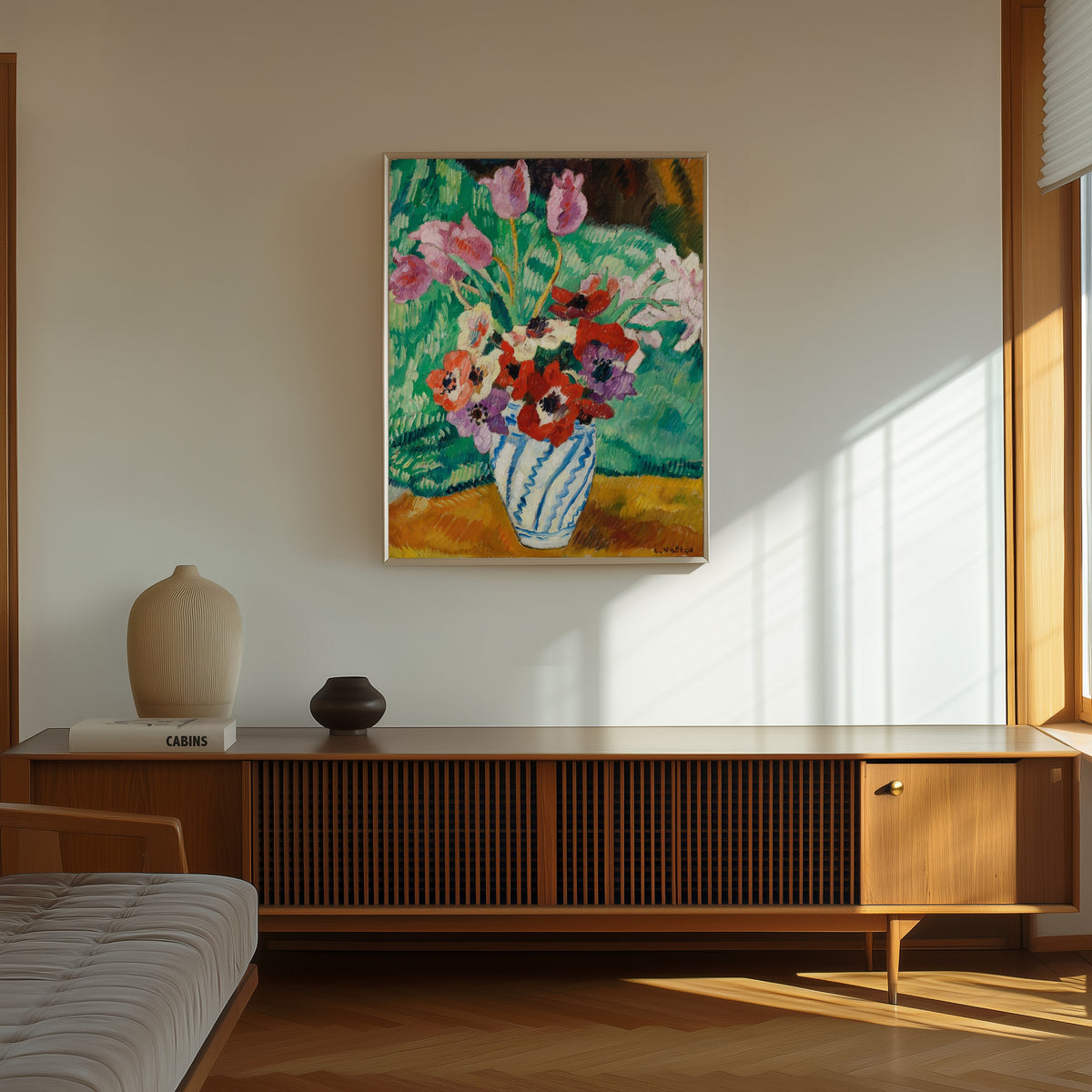 Framed art print of Tulips and Anemones by Louis Valtat, in a thin light frame on a sunlit wall above a wooden sideboard