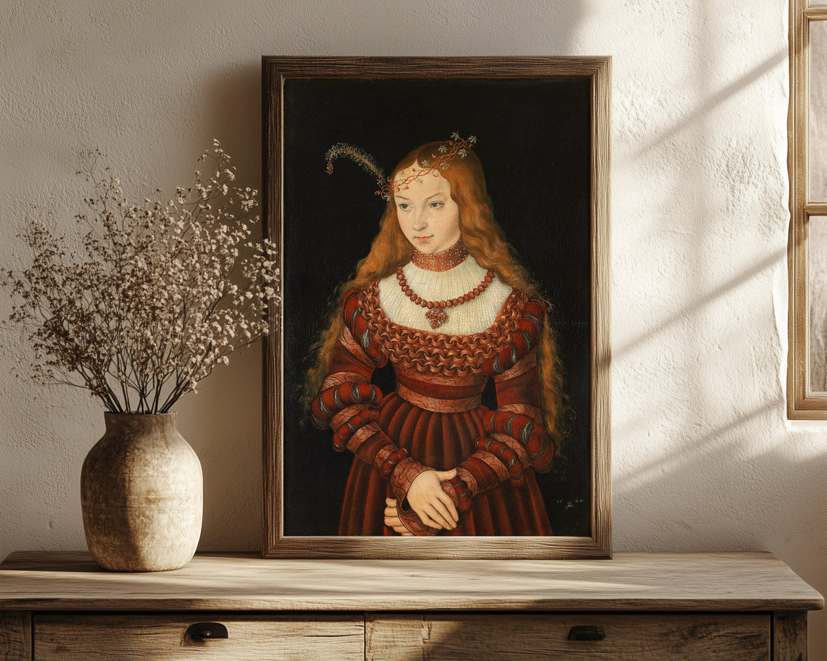 Framed art print of Portrait of Princess Sibylle of Cleves by Lucas Cranach the Elder, in a dark wood frame leaning on a rustic console beside dried flowers