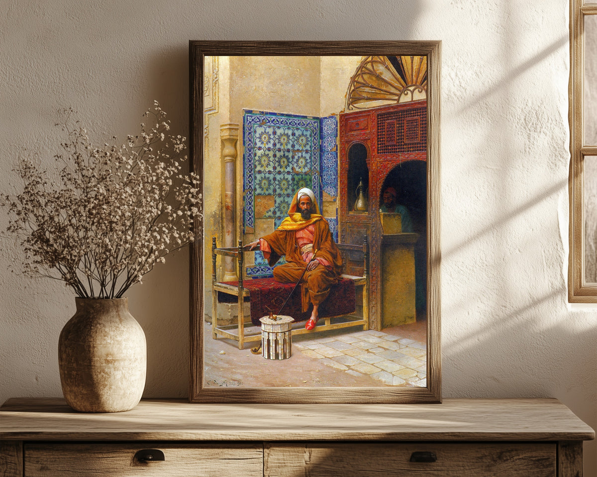 Framed art print of The Smoker by Ludwig Deutsch, in a dark wood frame leaning on a rustic console beside dried flowers