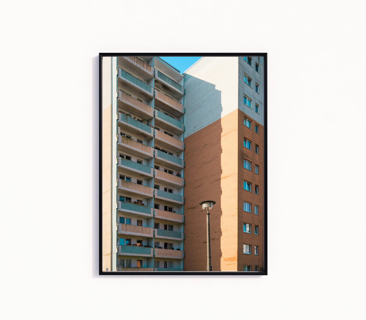 Framed art print of Light and Shadow V by Marcus Lenk, in a slim black frame on a plain white wall