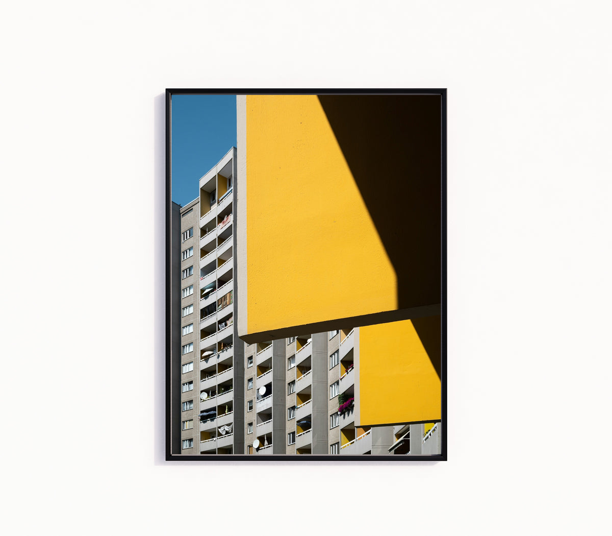 Framed art print of Light and Shadow VI by Marcus Lenk, in a slim black frame on a plain white wall
