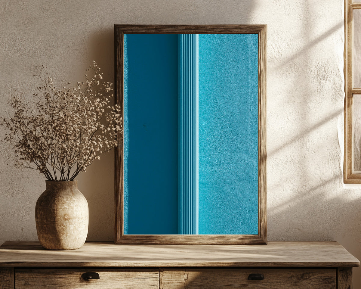 Framed art print of Light and Shadow VII by Marcus Lenk, in a dark wood frame leaning on a rustic console beside dried flowers