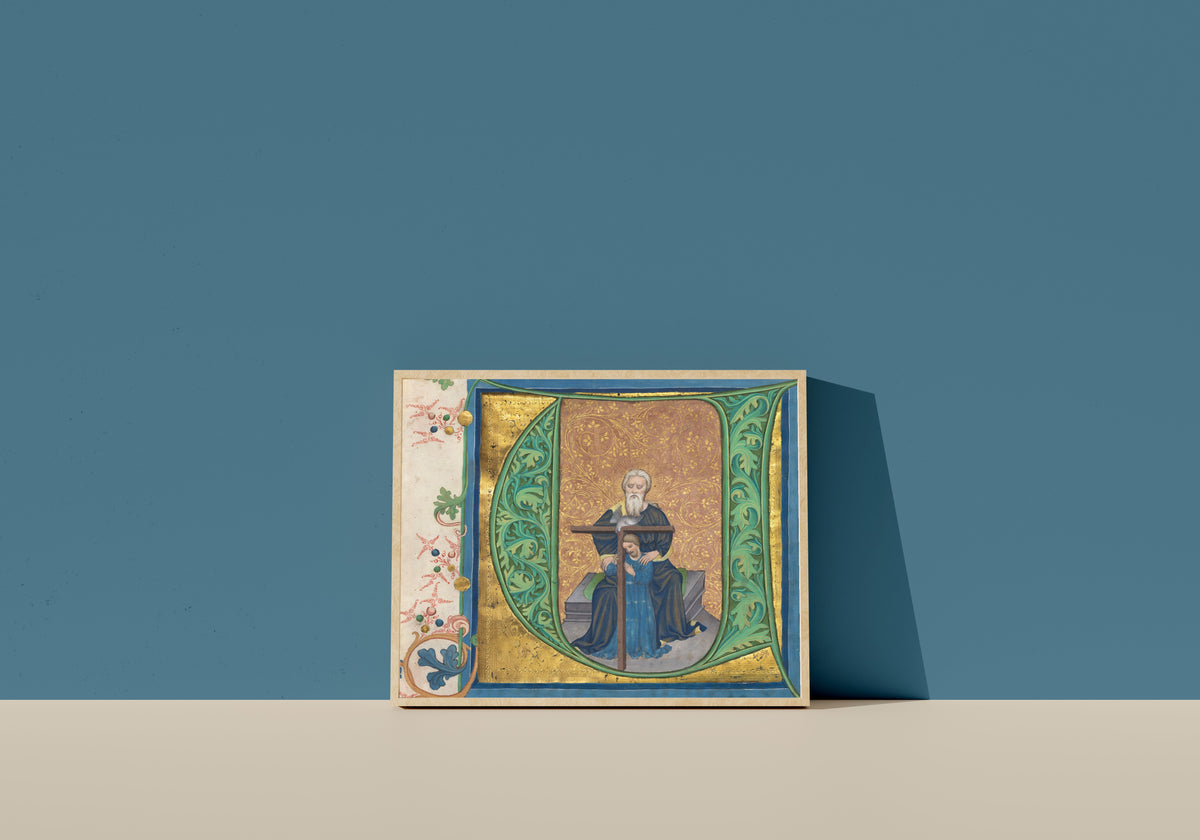 Framed art print of The Trinity by Master of the Gerona Martyrology (workshop), in a light wood frame leaning on a blue wall