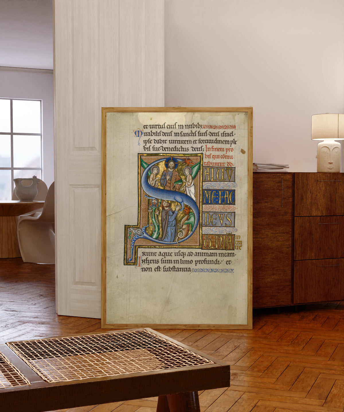 Framed art print of Initial S: David in Prayer by Master of the Ingeborg Psalter, in a light wood frame leaning in a warm room with a parquet floor