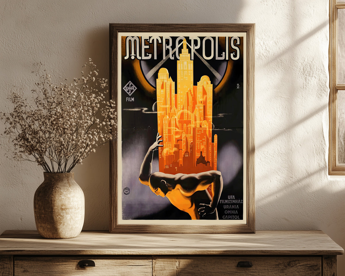 Framed art print of Metropolis Movie Poster by Heinz Schulz-Neudamm, in a dark wood frame leaning on a rustic console beside dried flowers
