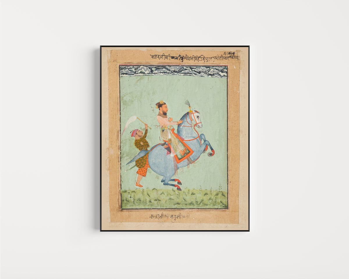 Framed art print of Prince Mathu Singh of Jatoli on a Blue Horse Riding to Udaipur by Mewar school, in a slim black frame on a plain white wall
