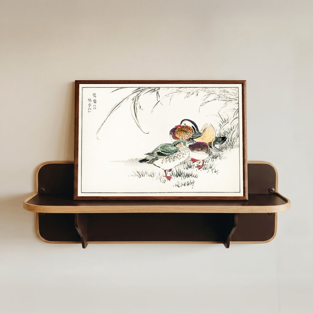 Framed art print of Mandarin Duck and Pearl Barley by Numata Kashū, in a dark wood frame resting on a wall shelf