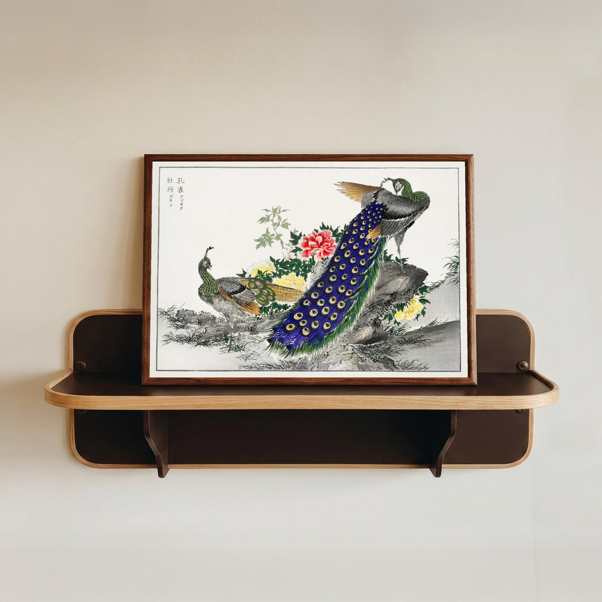 Framed art print of Peacock and Peony by Numata Kashū, in a dark wood frame resting on a wall shelf