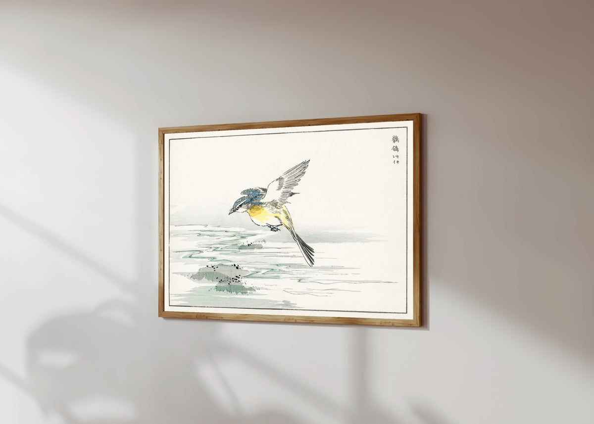 Framed art print of Wagtail over a Stream by Numata Kashū, in a light wood frame on a sunlit white wall, seen at a slight angle