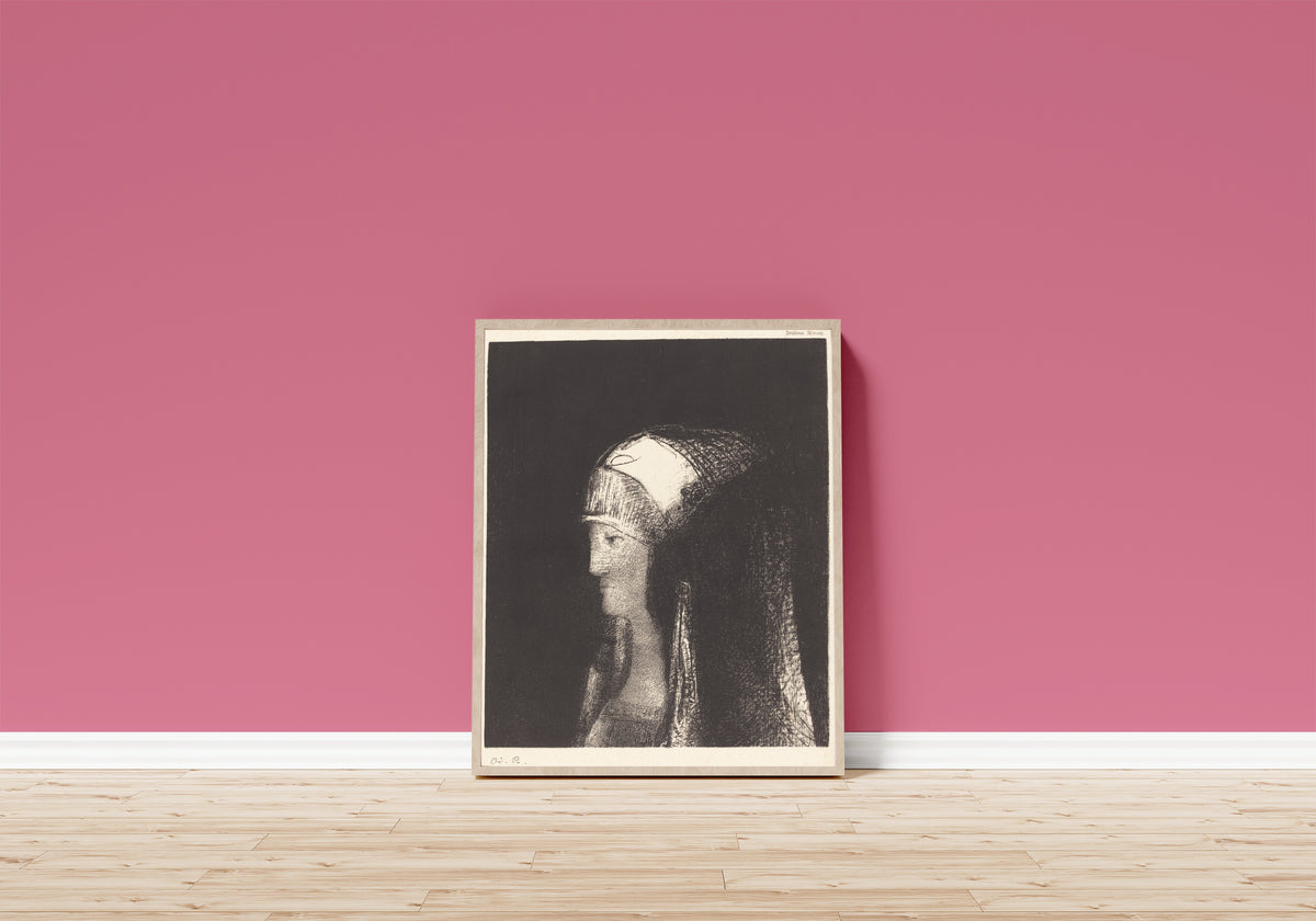 Framed art print of Druidess by Odilon Redon, in a light wood frame leaning on a pink wall above a wooden floor