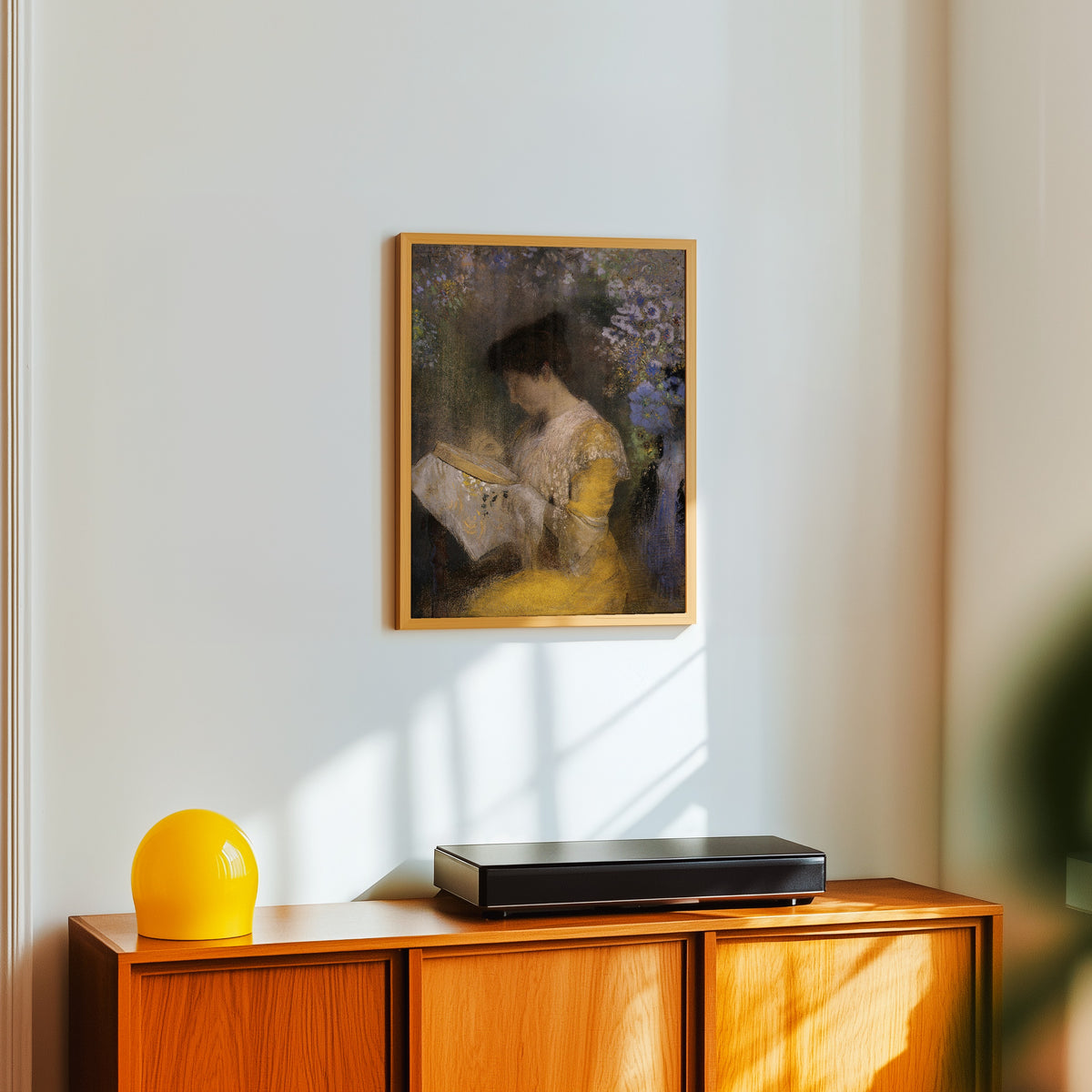 Framed art print of Madame Arthur Fontaine (Marie Escudier) by Odilon Redon, in a light wood frame on a white wall above an orange sideboard