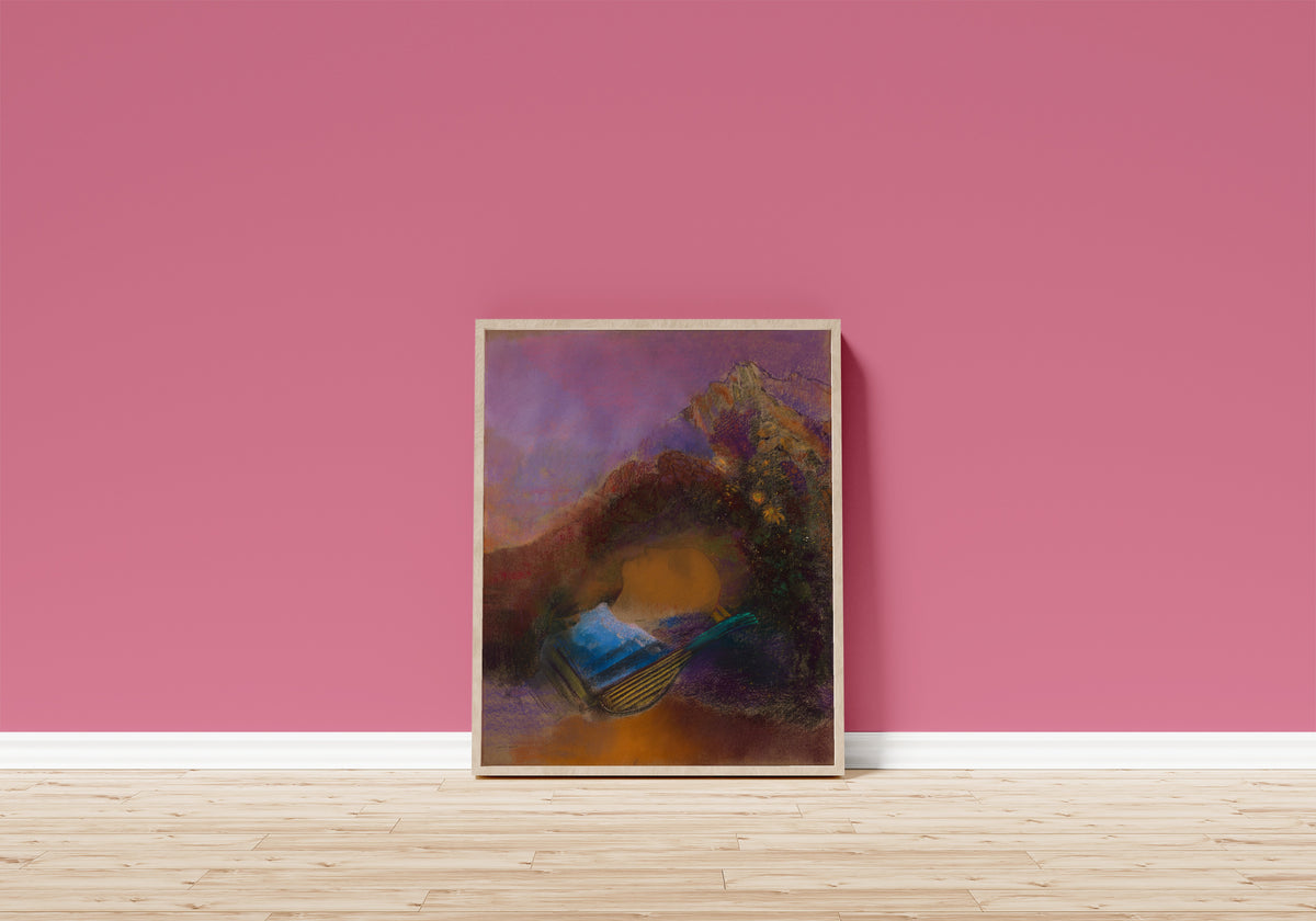 Framed art print of Orpheus by Odilon Redon, in a light wood frame leaning on a pink wall above a wooden floor