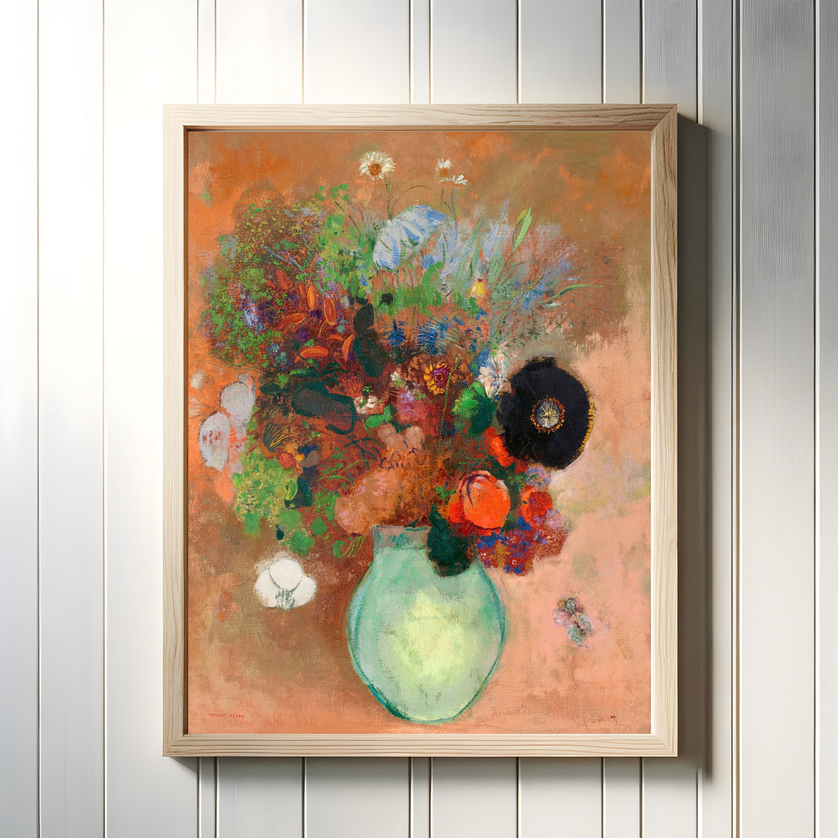 Framed art print of The Black Poppy by Odilon Redon, in a light wood frame on a white panelled wall