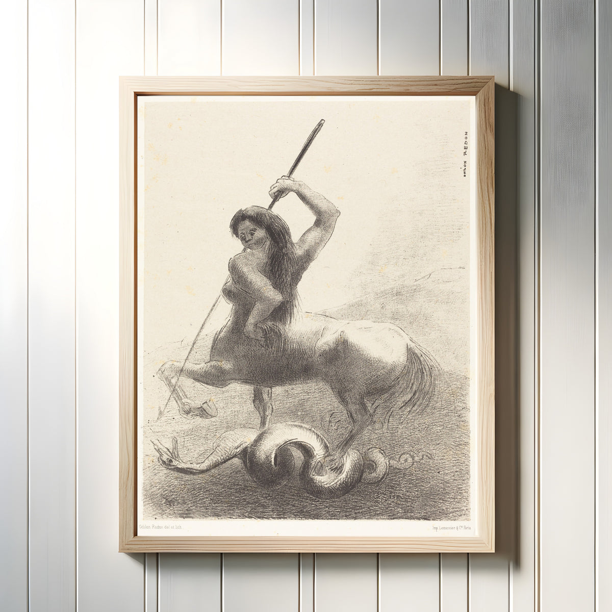 Framed art print of The Origins: There Were Struggles and Vain Victories by Odilon Redon, in a light wood frame on a white panelled wall