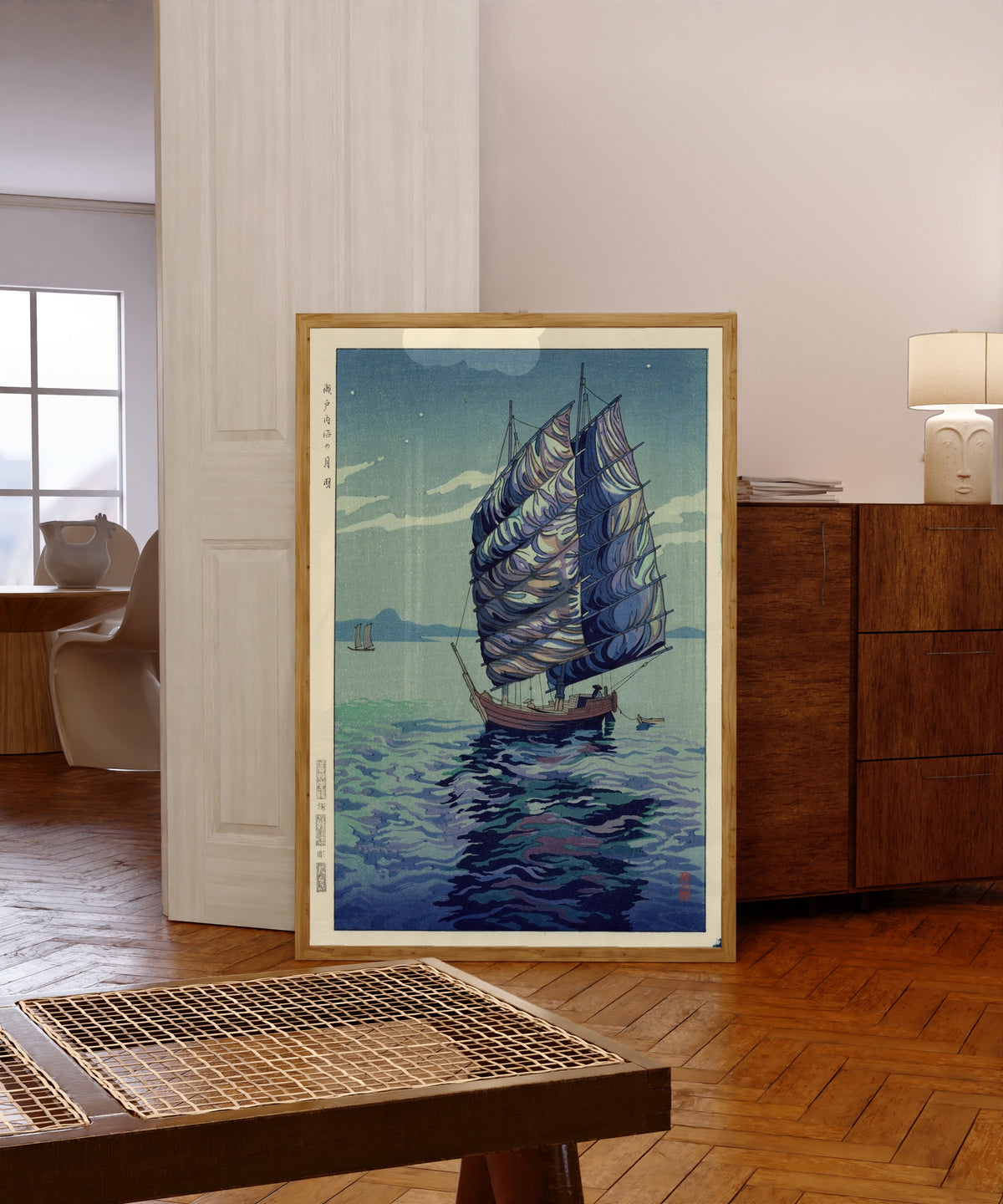 Framed art print of Moonlight Over Inland Sea by Okazaki Shintaro, in a light wood frame leaning in a warm room with a parquet floor