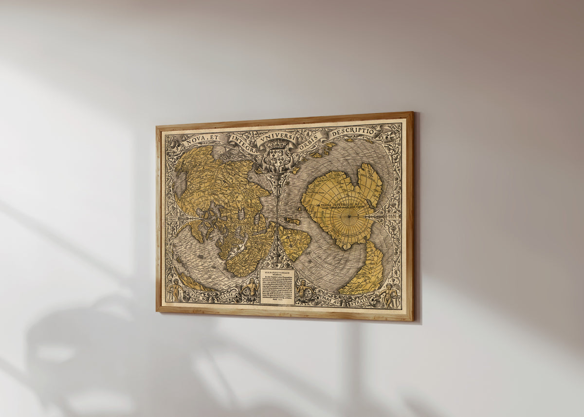 Framed art print of Nova et Integra Universi Orbis Descriptio by Oronce Finé, in a light wood frame on a sunlit white wall, seen at a slight angle