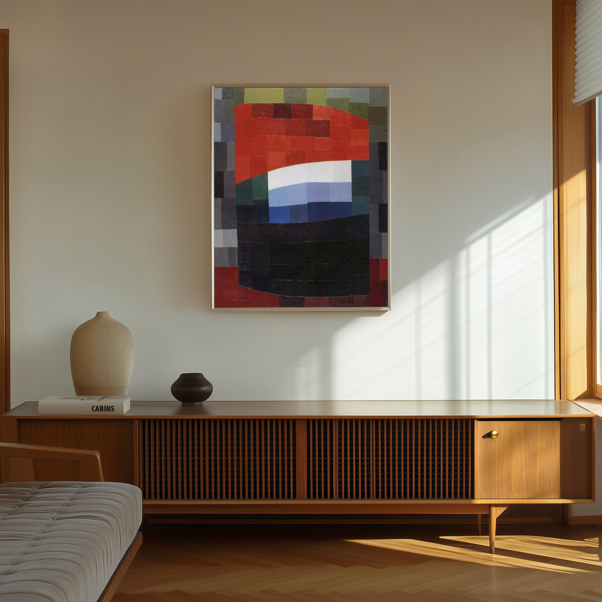 Framed art print of My Sky is Red (Mein Himmel ist rot) (1933) by Otto Freundlich, in a thin light frame on a sunlit wall above a wooden sideboard