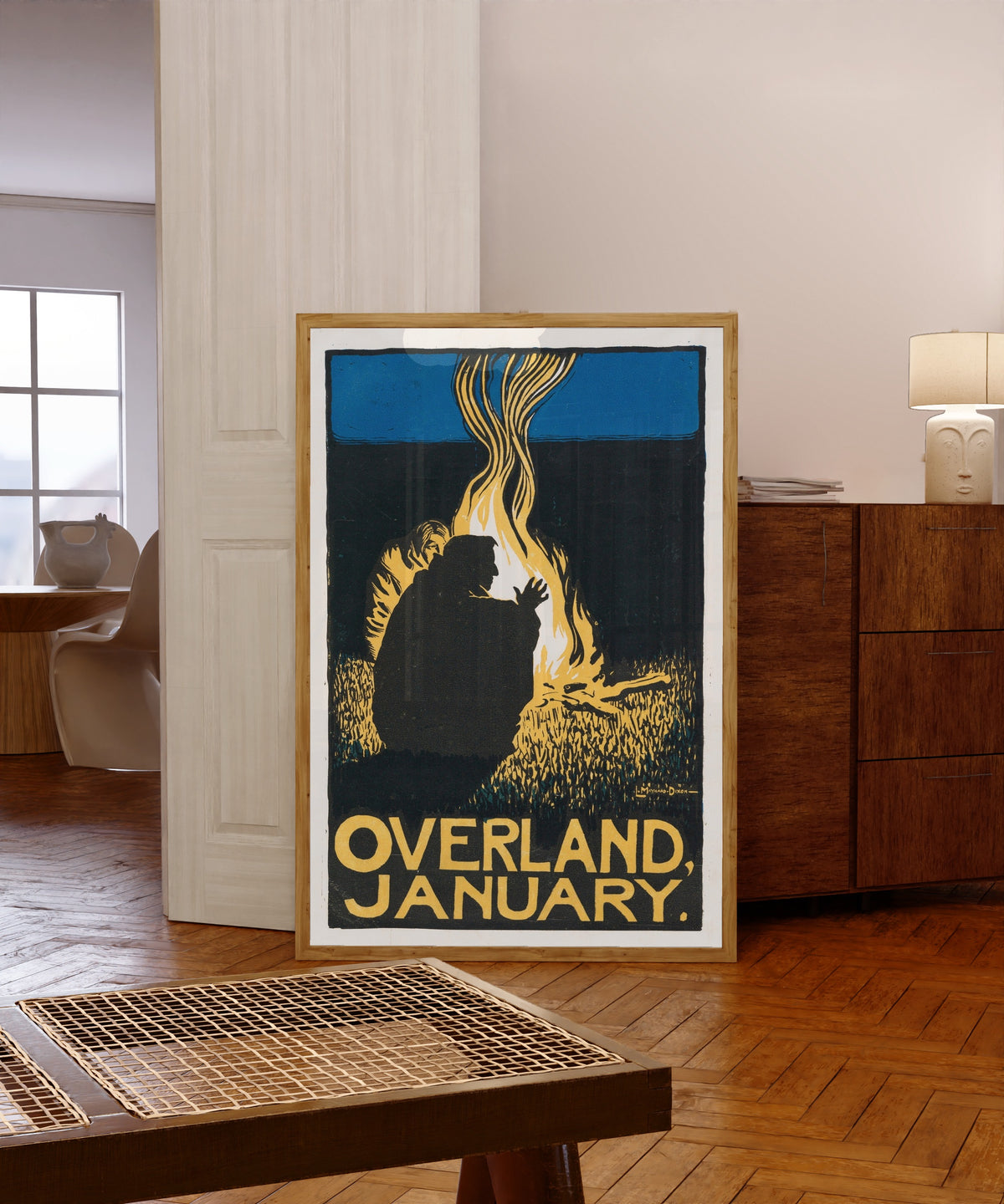 Framed art print of Overland Monthly (January 1896) by Maynard Dixon, in a light wood frame leaning in a warm room with a parquet floor
