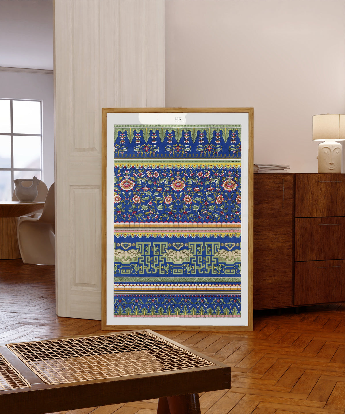 Framed art print of Example of Chinese Ornament Pl.53 (1867) by Owen Jones, in a light wood frame leaning in a warm room with a parquet floor