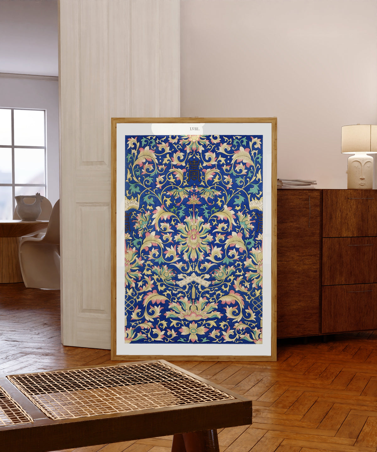 Framed art print of Example of Chinese Ornament, Plate 58 by Owen Jones, in a light wood frame leaning in a warm room with a parquet floor