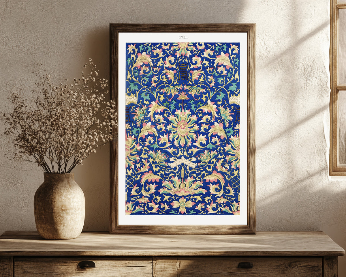 Framed art print of Example of Chinese Ornament, Plate 58 by Owen Jones, in a dark wood frame leaning on a rustic console beside dried flowers