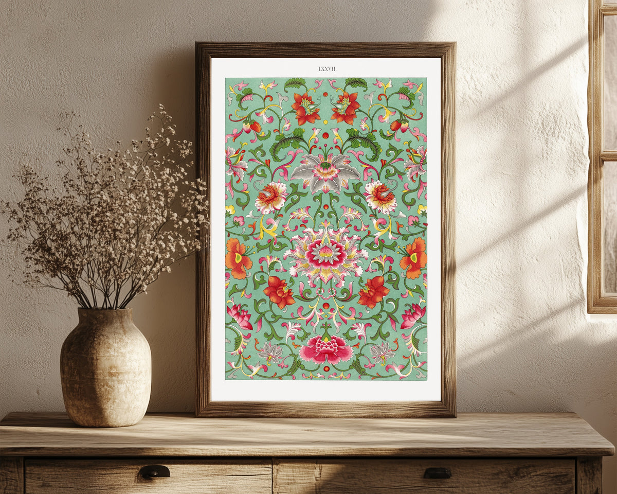 Framed art print of Example of Chinese Ornament, Plate 77 by Owen Jones, in a dark wood frame leaning on a rustic console beside dried flowers