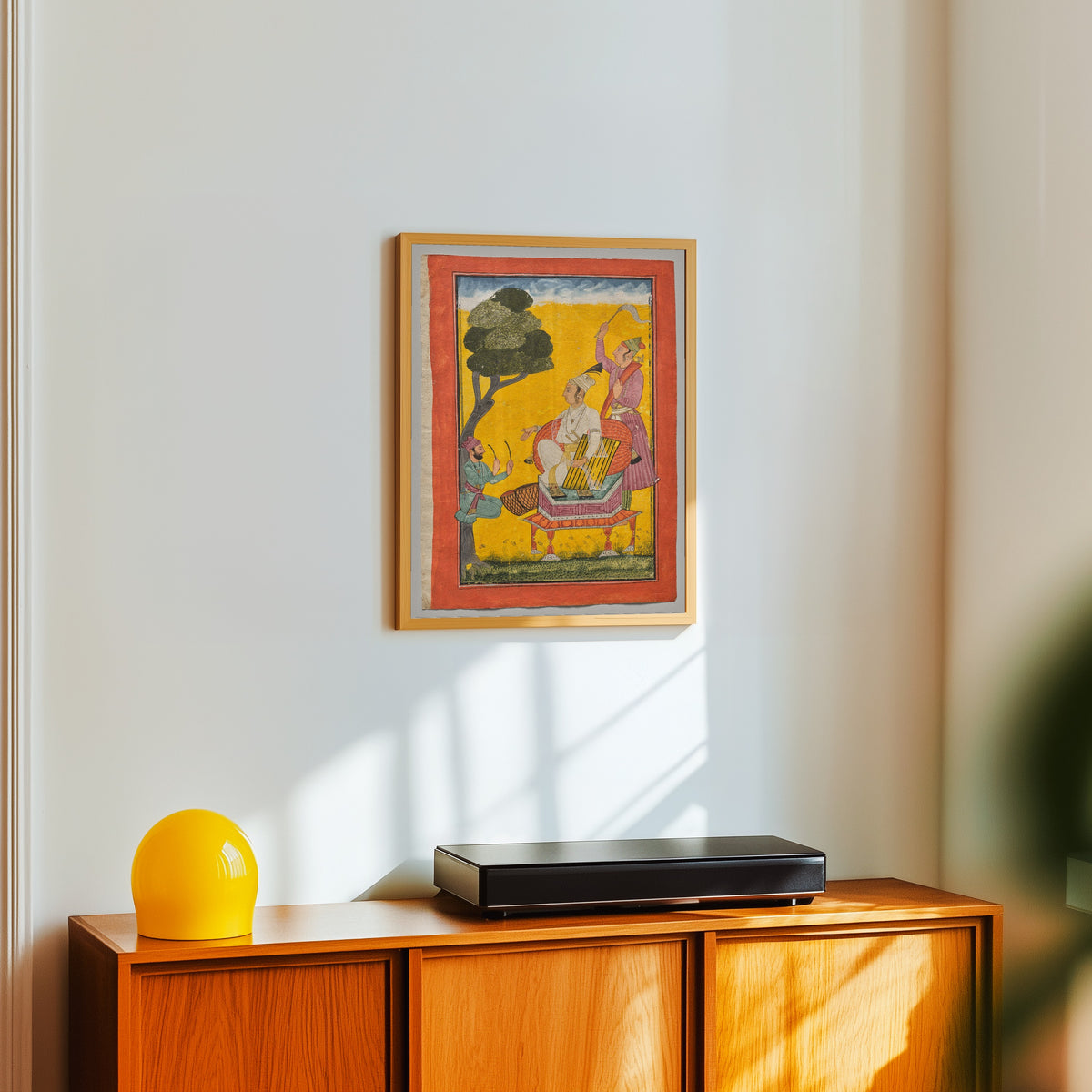 Framed art print of Vivacha Ragaputra, from a Ragamala by Pahari school, in a light wood frame on a white wall above an orange sideboard