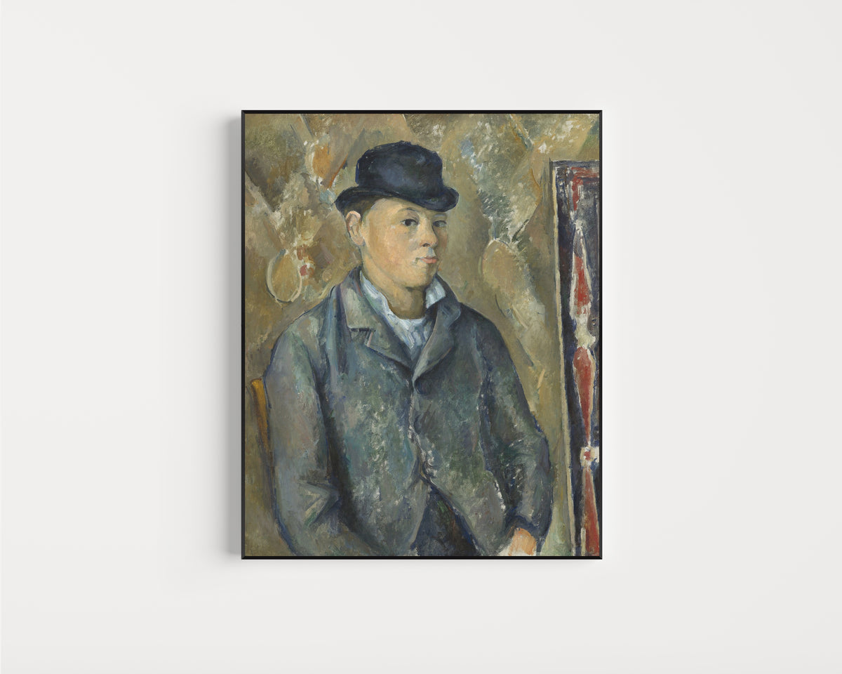 Framed art print of The Artist's Son, Paul by Paul Cezanne, in a slim black frame on a plain white wall