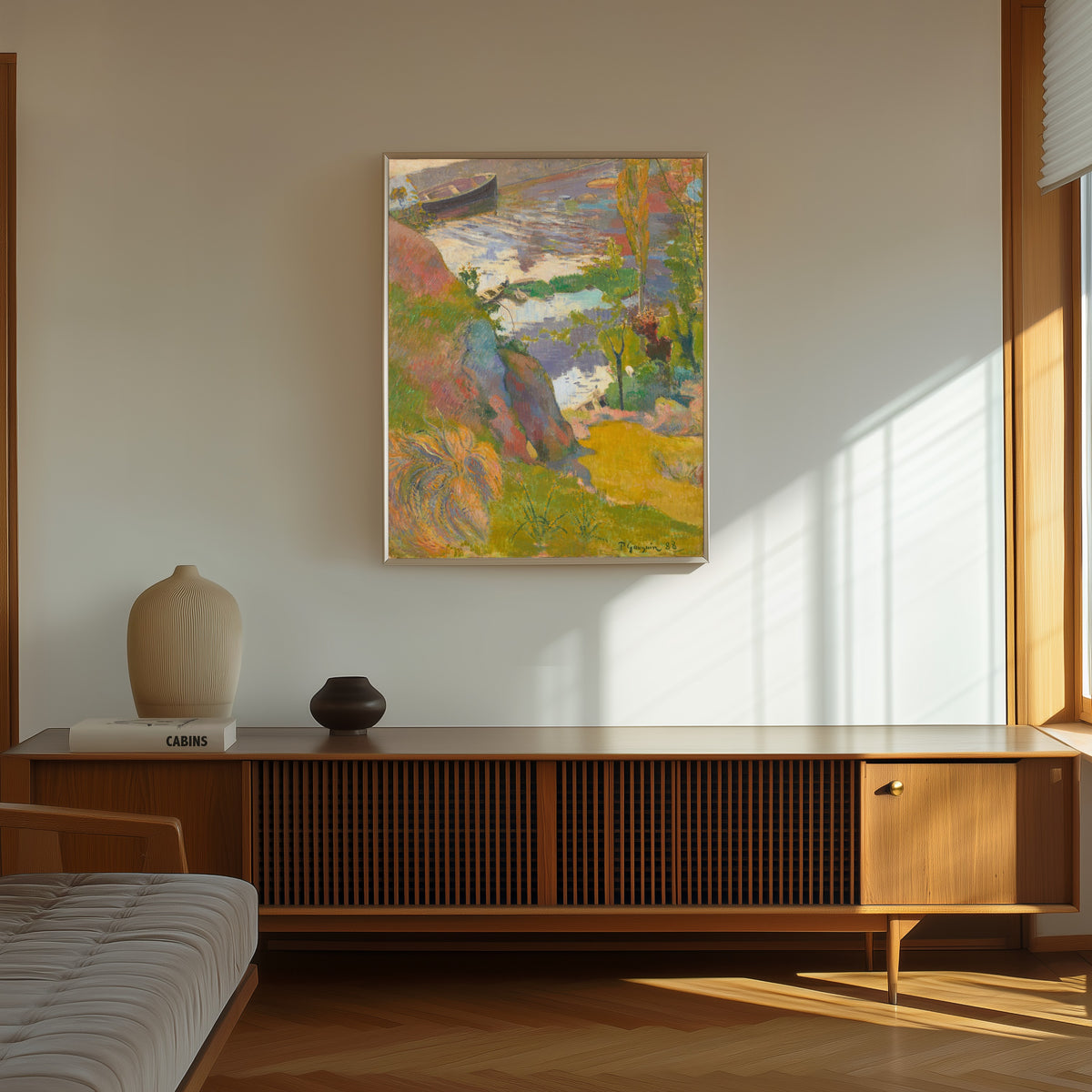 Framed art print of Fisherman and Bathers on the Aven by Paul Gauguin, in a thin light frame on a sunlit wall above a wooden sideboard