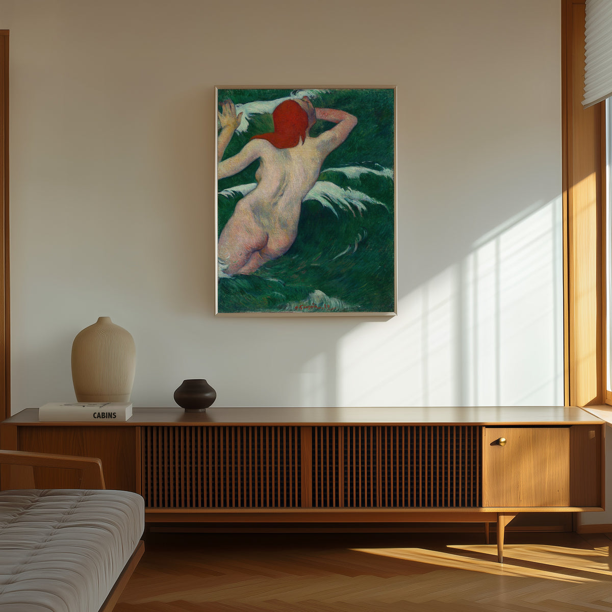Framed art print of In the Waves (Ondine) by Paul Gauguin, in a thin light frame on a sunlit wall above a wooden sideboard