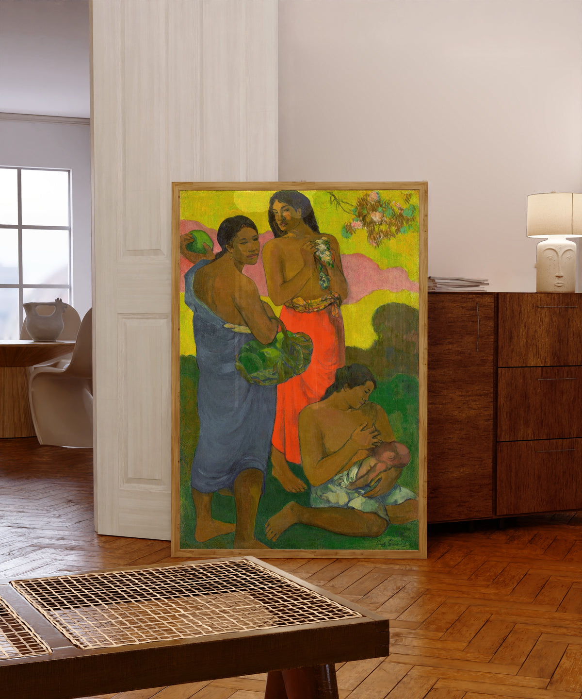 Framed art print of Maternité II by Paul Gauguin, in a light wood frame leaning in a warm room with a parquet floor