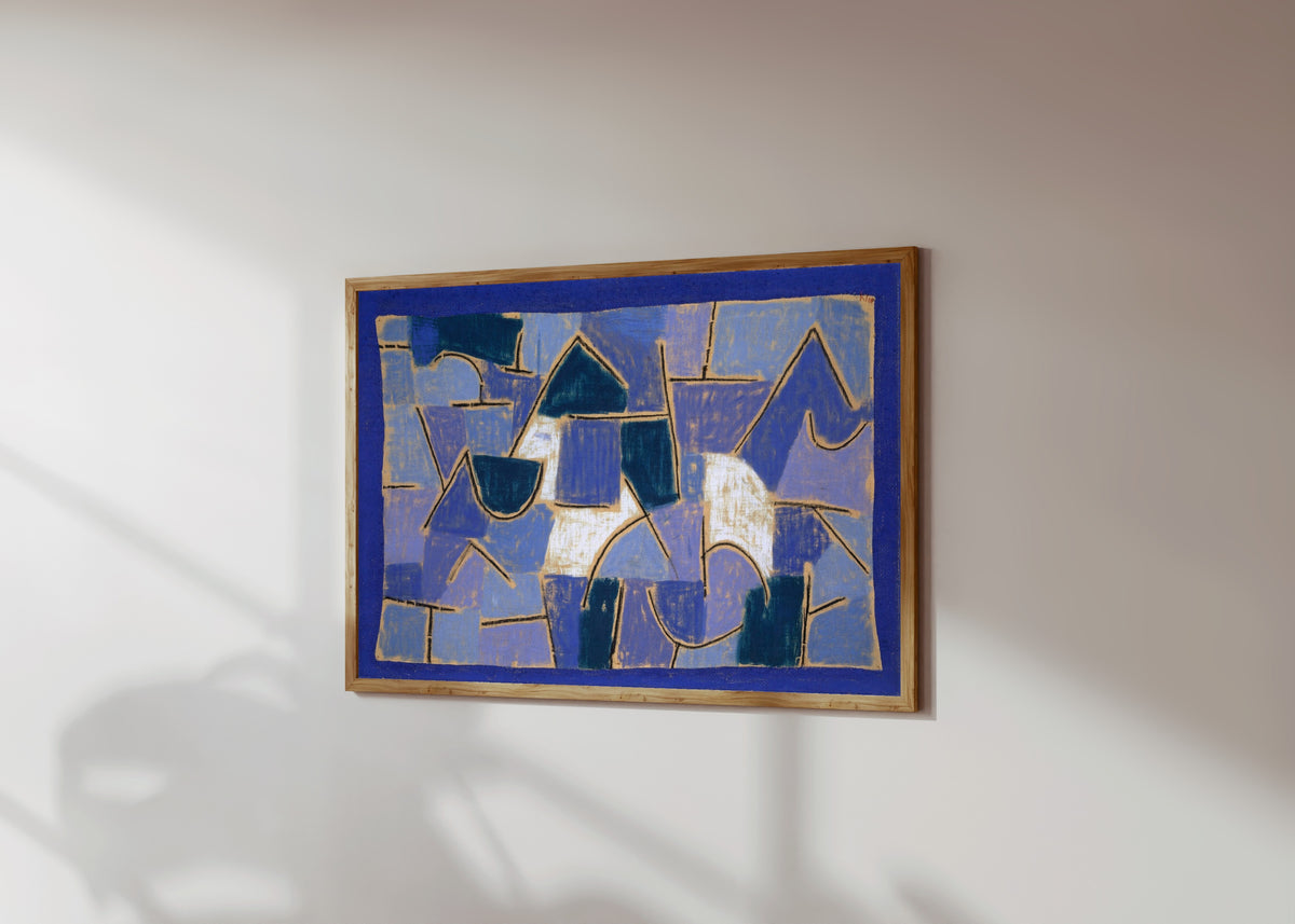 Framed art print of Blue Night by Paul Klee, in a light wood frame on a sunlit white wall, seen at a slight angle