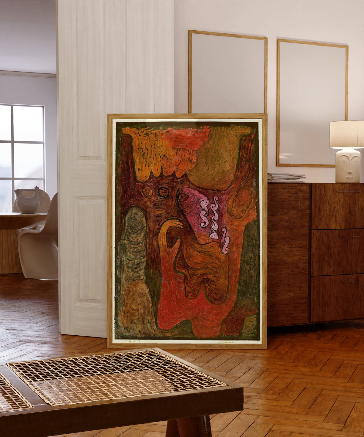 Framed art print of Dryads by Paul Klee, in a light wood frame leaning in a warm room with a parquet floor